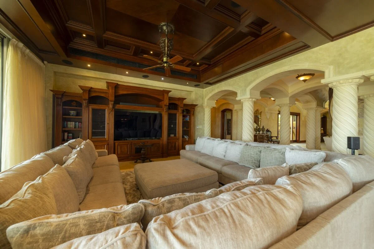 luxury villa living room in los suenos with large sectional sofa media center and coffered ceiling