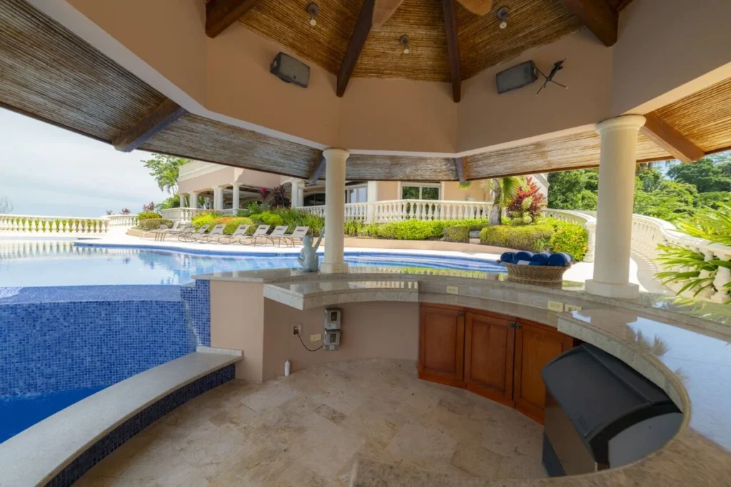 A covered poolside bar designed for effortless outdoor living, just steps from the water and surrounded by open-air terraces.