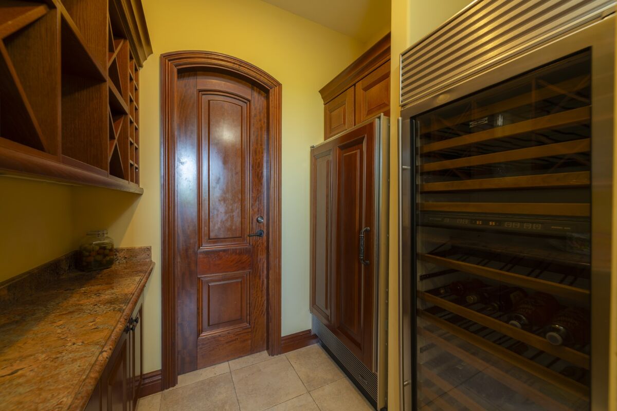 luxury villa wine cooler and pantry area in los suenos with storage shelves and cabinetry