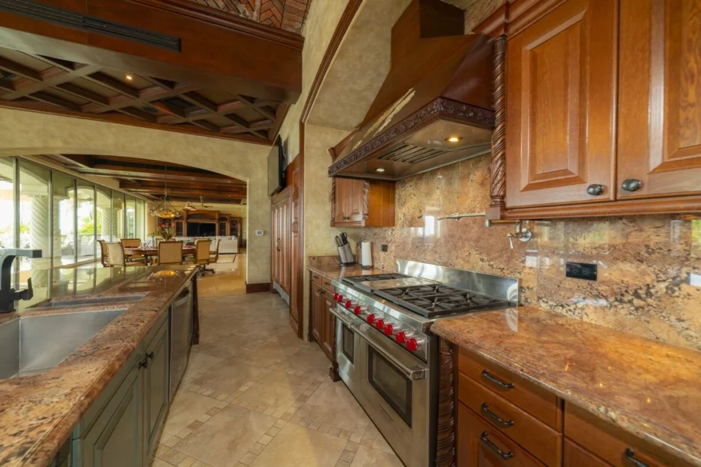 A fully equipped gourmet kitchen with custom cabinetry and expansive granite countertops, designed for both everyday use and entertaining.