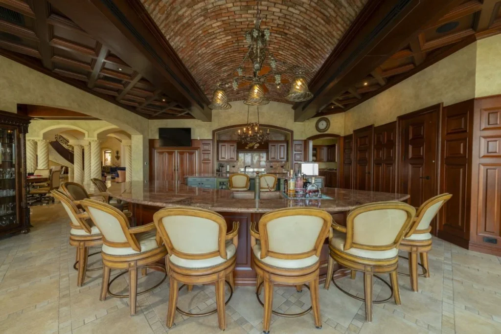 A custom bar and kitchen space beneath a vaulted brick ceiling, designed for entertaining with style and ease.
