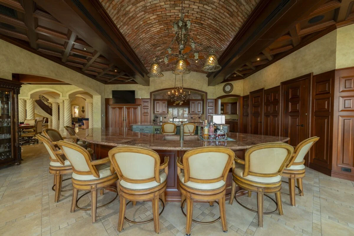 luxury villa bar and kitchen in los suenos with vaulted brick ceiling wood cabinetry and seating
