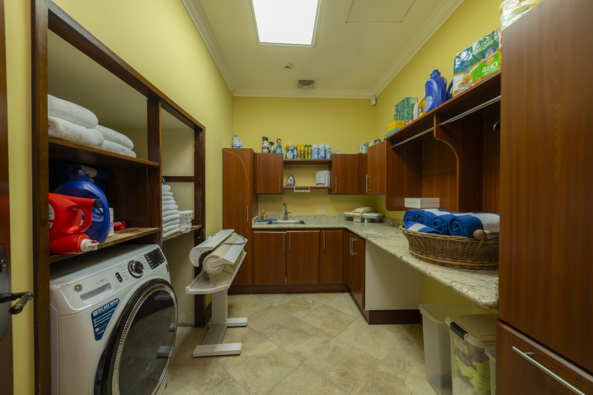 luxury villa laundry room in los suenos with washer dryer folding area and storage cabinets