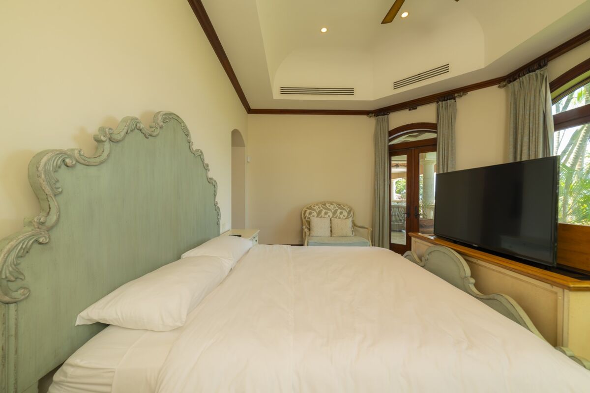 luxury villa bedroom in los suenos with terrace access upholstered headboard and tv