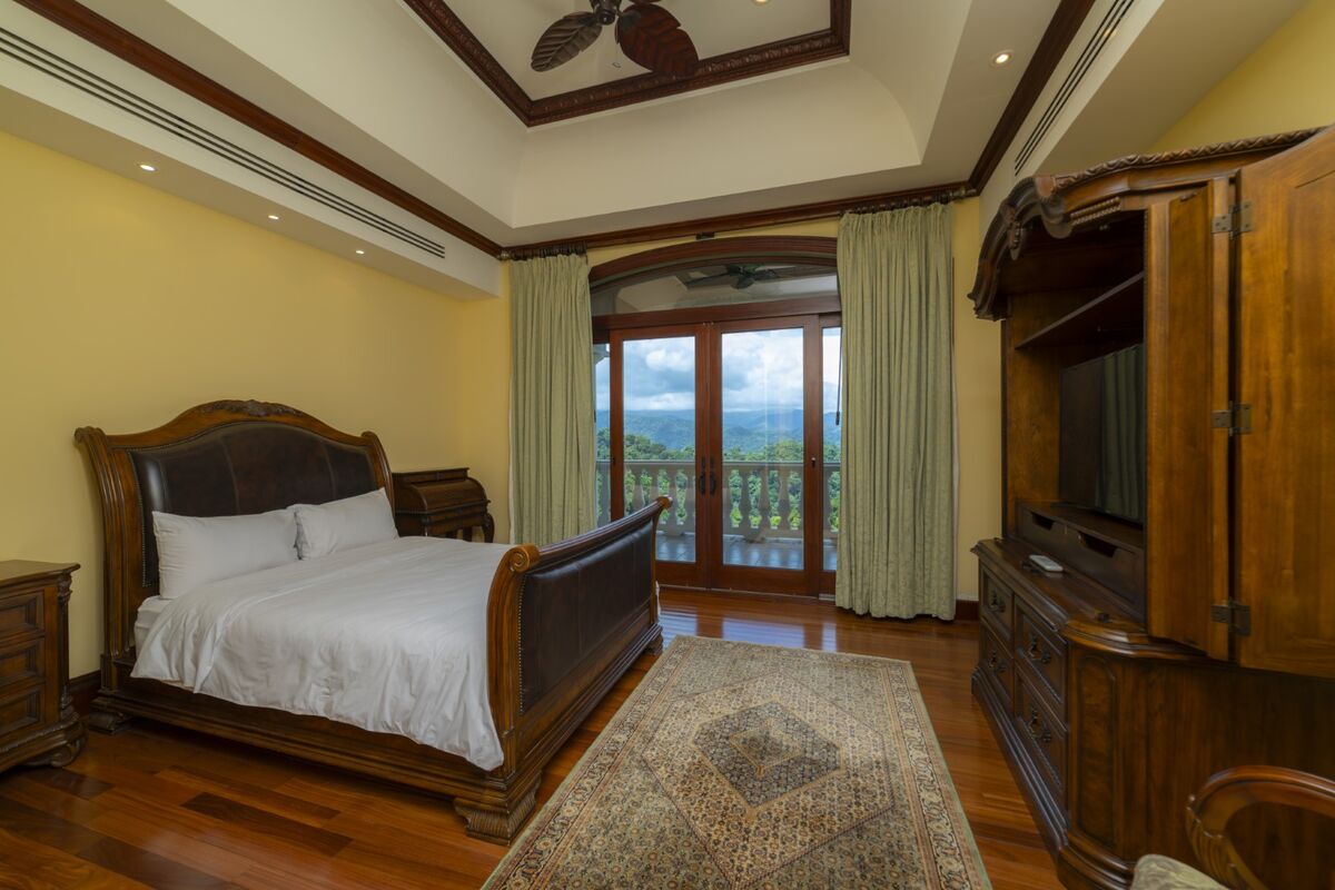 luxury villa bedroom in los suenos with balcony mountain views hardwood floors and tv