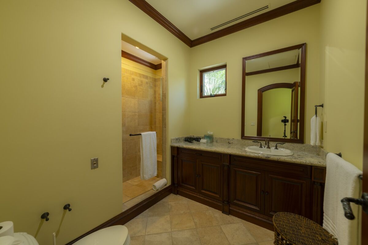 luxury villa bathroom in los suenos with walk in shower granite countertop and wood cabinetry