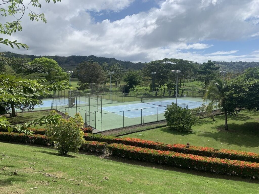 Tennis courts at Los Sueños, set within a lush tropical landscape.