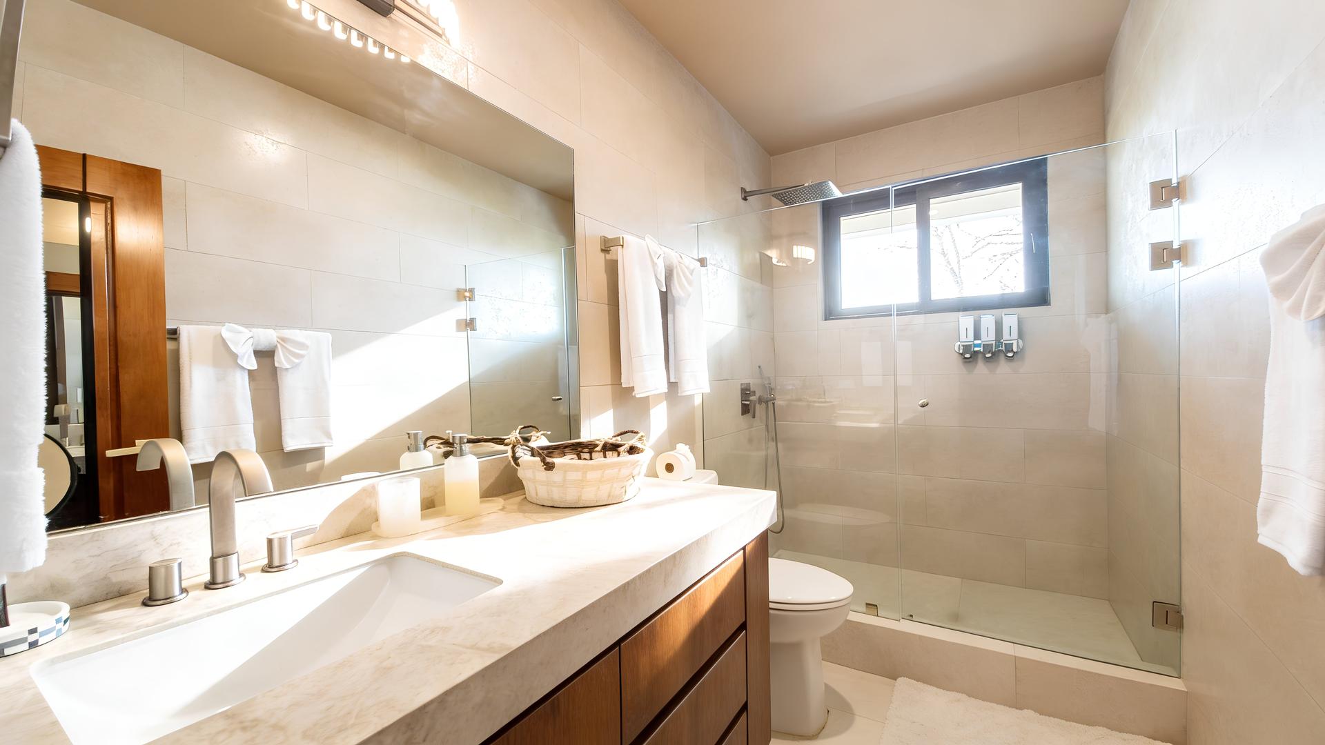 Luxury bathroom with rainfall shower and modern vanity in a Costa Rica beachfront vacation villa