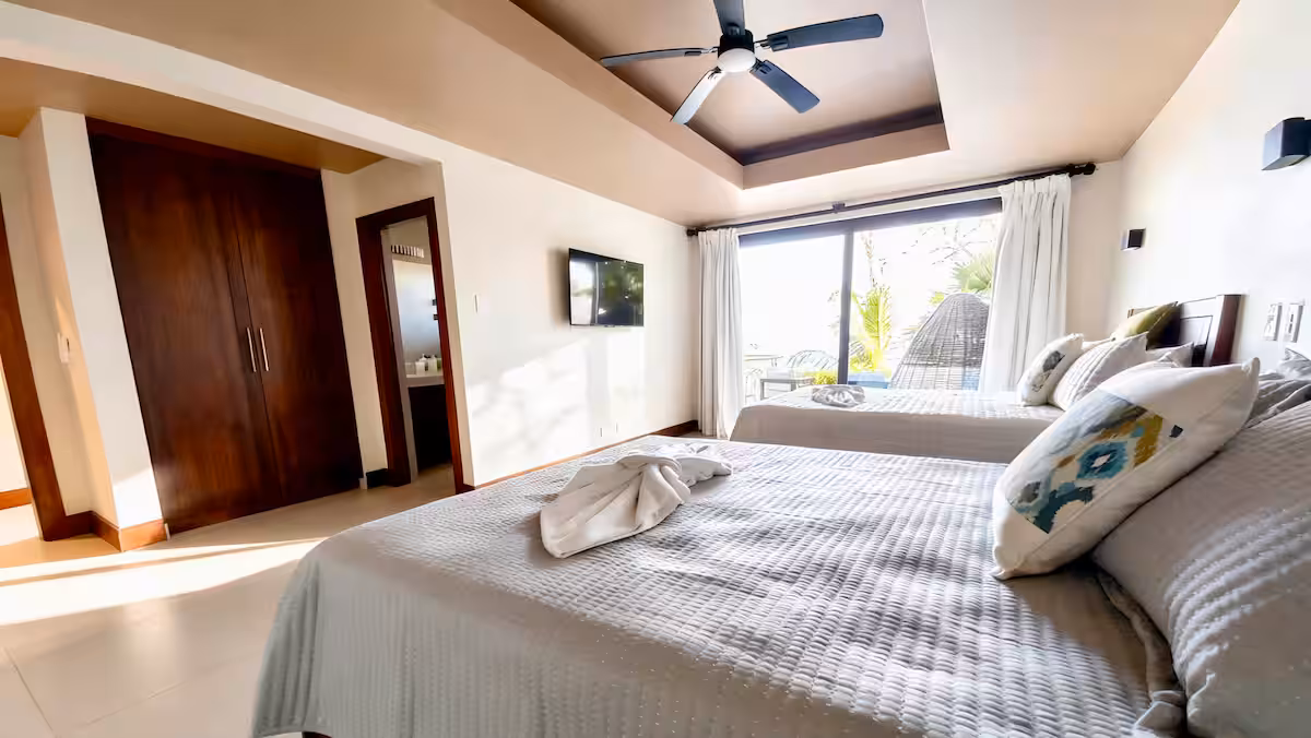 Guest bedroom with two queen beds and ocean views in a Costa Rica luxury beachfront villa
