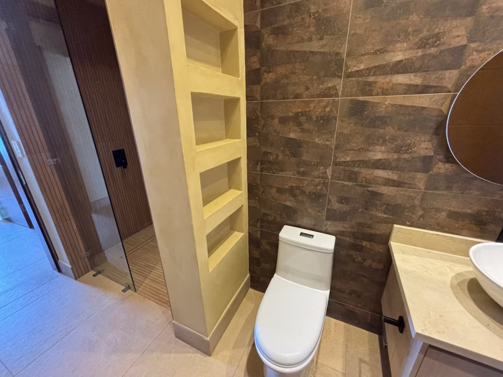 Natural stone finishes and a spacious walk-in rain shower create a refreshing place to unwind after a day of exploring the Nicoya Peninsula.
