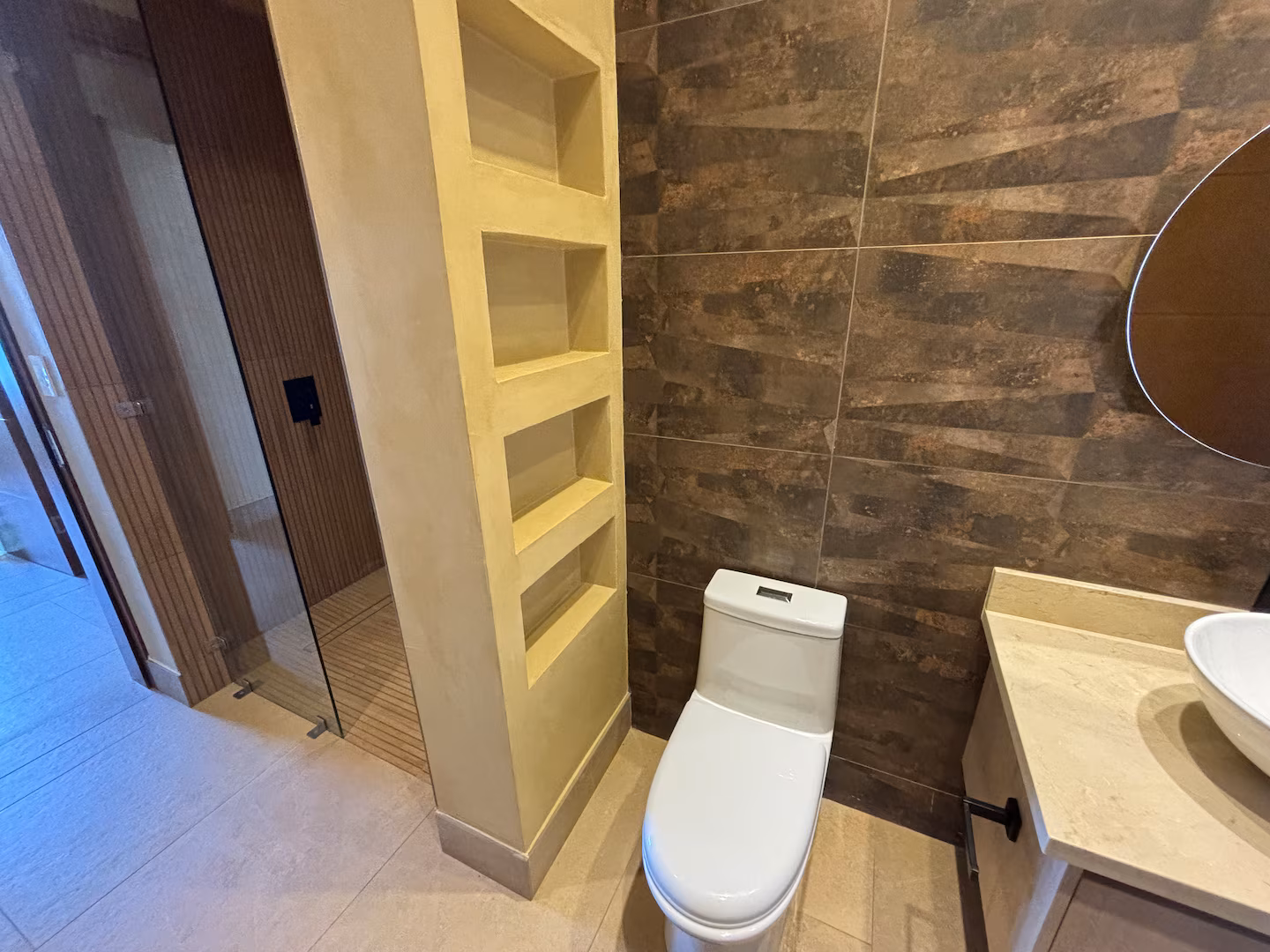 Modern bathroom with walk-in rain shower, vessel sink, and natural stone finishes in a Costa Rica vacation villa