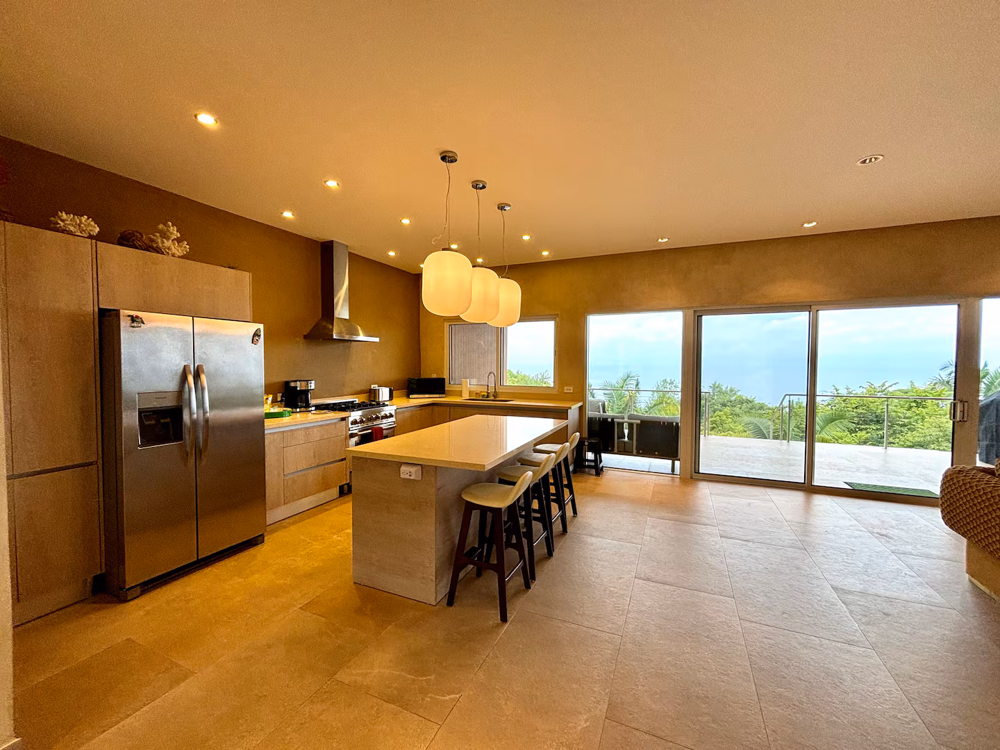 Open-concept kitchen with large island and Pacific Ocean views at a family vacation villa in Costa Rica