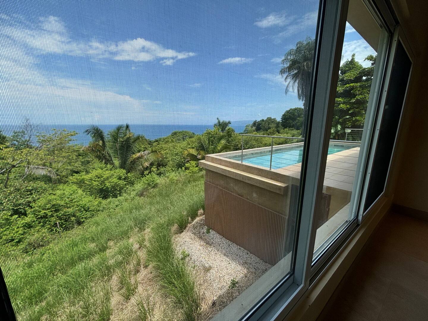 Bedroom view overlooking a private pool and Pacific Ocean in a family vacation villa in Costa Rica