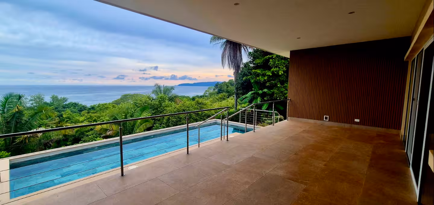Covered terrace overlooking a private pool and the Pacific Ocean at a Costa Rica family vacation villa